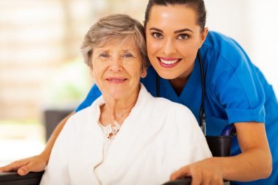 Nurse with a smiling older woman in a wheelchair